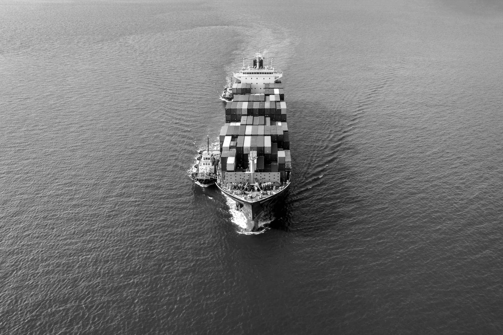 Container ship with a tug alongside, seen from above